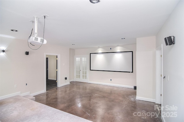 home theater with baseboards and finished concrete flooring