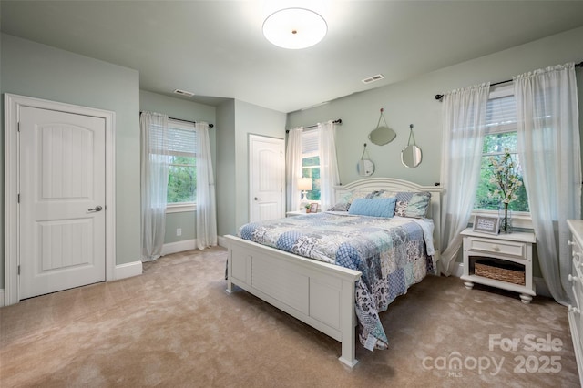 bedroom featuring baseboards, light colored carpet, and visible vents