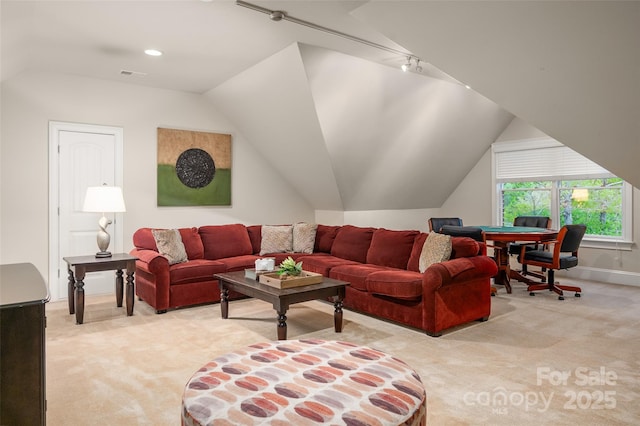 living room featuring light carpet, rail lighting, and lofted ceiling