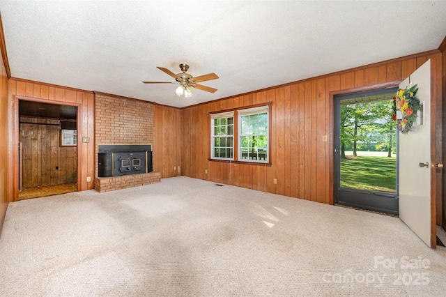 2415 Hargette Rd, Monroe, NC 28112 - unfurnished living room featuring ceiling fan, ornamental molding, visible vents, carpet flooring, and wooden walls