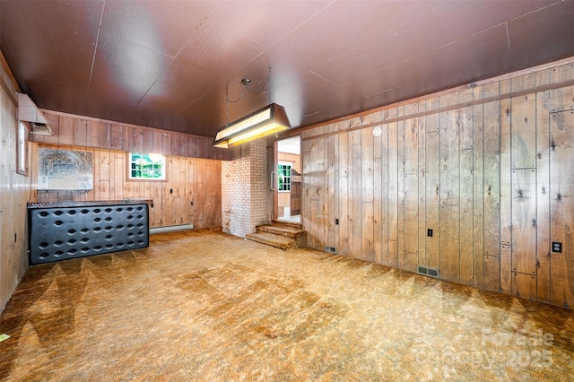 2415 Hargette Rd, Monroe, NC 28112 - unfurnished room with a baseboard radiator, visible vents, wood walls, and carpet