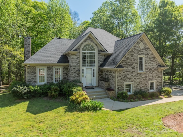 108 Tall Oak Dr, Mooresville, NC 28117 - view of front facade with roof with shingles, brick siding, a chimney, and a front lawn