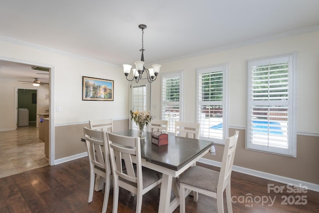 dining area featuring a chandelier, crown molding, healthy amount of natural light, dark wood-style floors, and baseboards