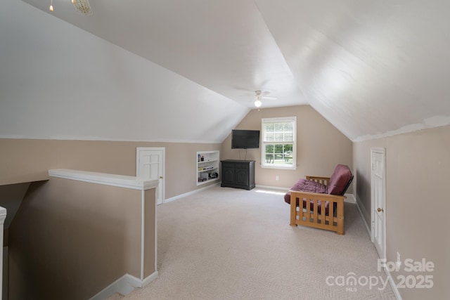 living area with lofted ceiling, baseboards, carpet floors, an upstairs landing, and ceiling fan