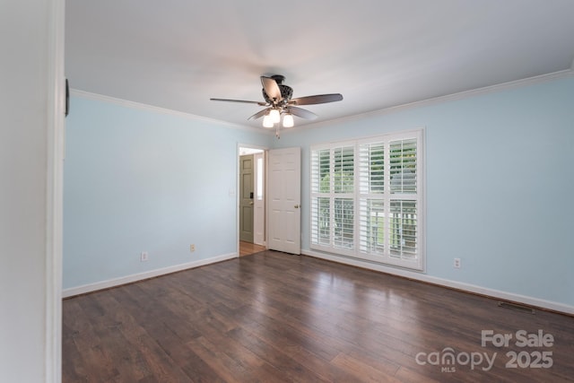 spare room with wood finished floors, ceiling fan, ornamental molding, and baseboards