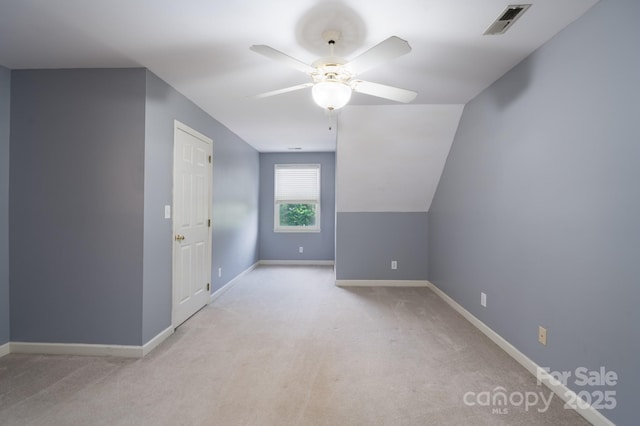additional living space with a ceiling fan, light colored carpet, and baseboards