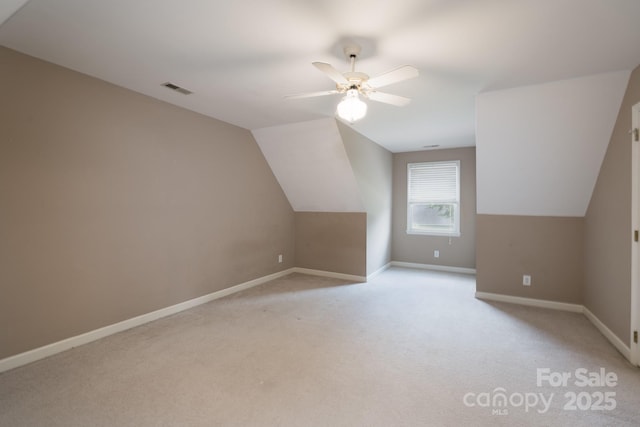 additional living space featuring ceiling fan, light colored carpet, baseboards, and lofted ceiling
