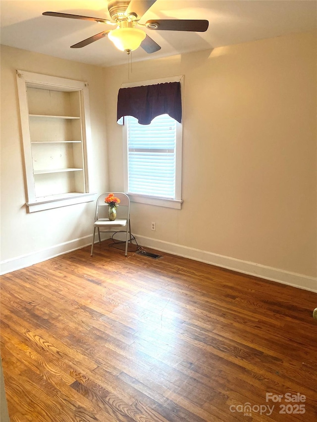 1410 Delwood Dr SW, Lenoir, NC 28645 - spare room with baseboards, built in features, a ceiling fan, visible vents, and wood finished floors