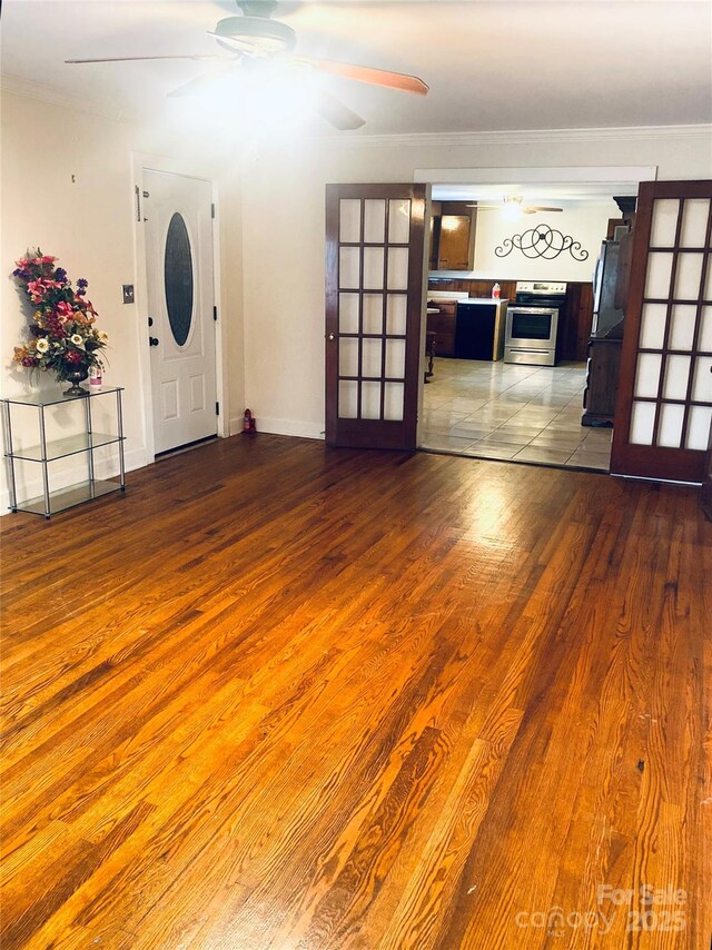 1410 Delwood Dr SW, Lenoir, NC 28645 - unfurnished living room with ornamental molding, baseboards, a ceiling fan, and wood finished floors