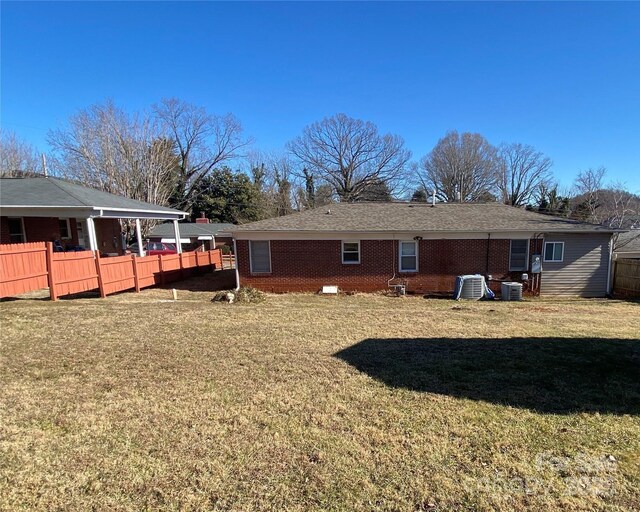 1410 Delwood Dr SW, Lenoir, NC 28645 - rear view of house with cooling unit, a lawn, fence, and brick siding