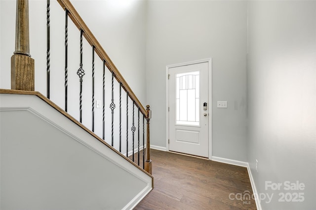 entrance foyer with baseboards, a high ceiling, wood finished floors, and stairway