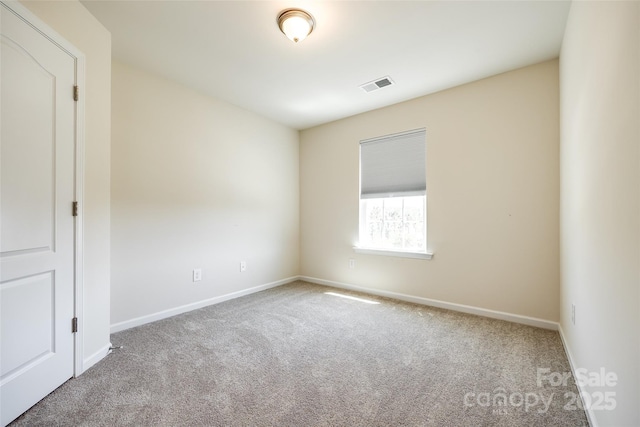 empty room featuring baseboards, carpet, and visible vents