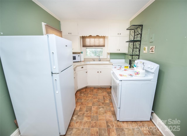 kitchen with washer / clothes dryer, white appliances, light countertops, white cabinets, and a sink