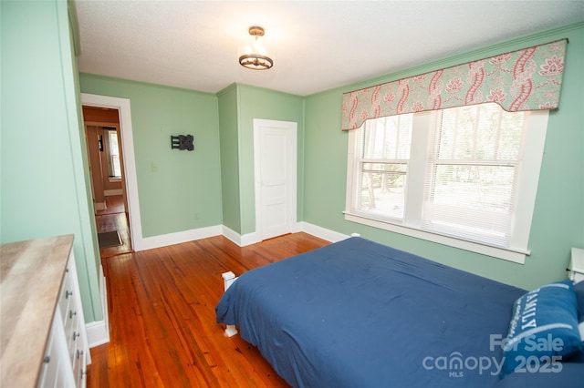 bedroom featuring baseboards and wood finished floors