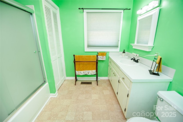bathroom featuring vanity, a closet, baseboards, an enclosed shower, and toilet