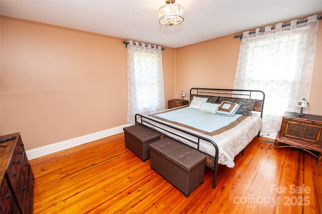 bedroom with hardwood / wood-style floors, crown molding, and baseboards
