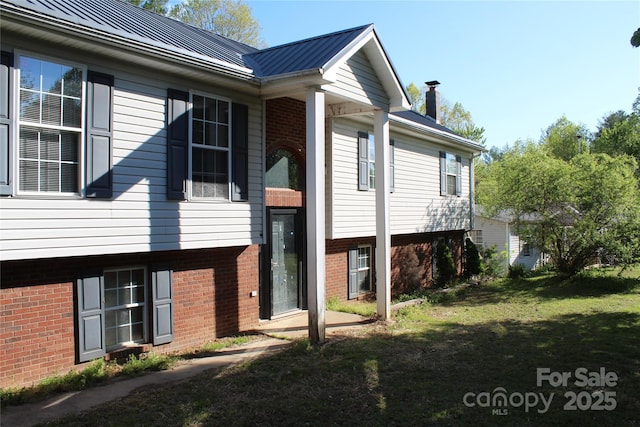5164 Ralph Winchester Rd, Lenoir, NC 28645 - view of property exterior featuring brick siding, a chimney, a lawn, and metal roof