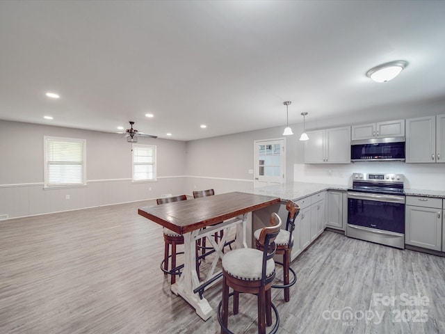 1315 Holshouser Rd, Rockwell, NC 28138 - kitchen featuring light wood-style flooring, ceiling fan, decorative light fixtures, and stainless steel appliances