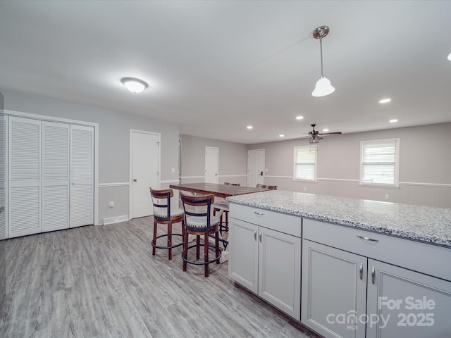 1315 Holshouser Rd, Rockwell, NC 28138 - kitchen featuring light stone counters, visible vents, ceiling fan, light wood finished floors, and hanging light fixtures