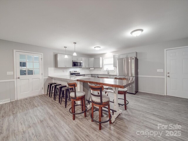 1315 Holshouser Rd, Rockwell, NC 28138 - kitchen featuring a sink, a kitchen breakfast bar, light wood-style floors, a peninsula, and stainless steel appliances