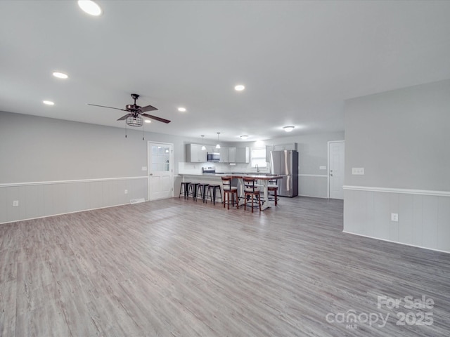 1315 Holshouser Rd, Rockwell, NC 28138 - living area featuring a ceiling fan, wainscoting, and light wood-style floors