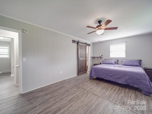 1315 Holshouser Rd, Rockwell, NC 28138 - bedroom with wood finished floors, ceiling fan, multiple windows, and a barn door