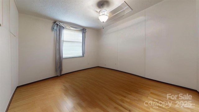 spare room featuring a textured ceiling and wood finished floors