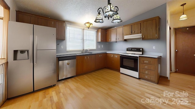 kitchen featuring a notable chandelier, light wood-style flooring, a textured ceiling, under cabinet range hood, and stainless steel appliances