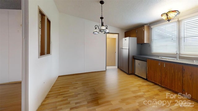 kitchen featuring an inviting chandelier, dishwasher, freestanding refrigerator, a textured ceiling, and light wood-style flooring