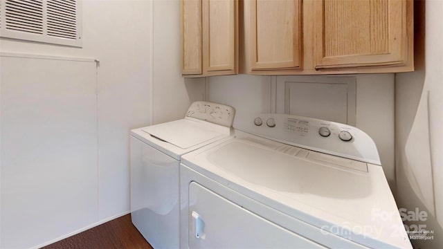 laundry area with visible vents, cabinet space, and washing machine and dryer