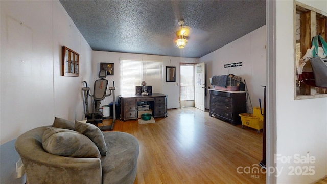 interior space featuring light wood-type flooring and a textured ceiling