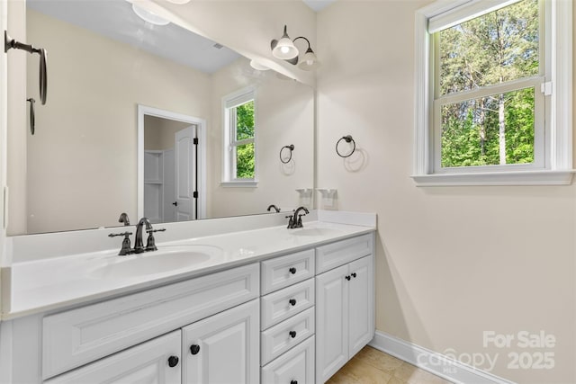 full bathroom with double vanity, tile patterned flooring, and baseboards
