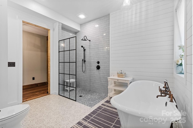 full bath with a walk in shower, a freestanding tub, and toilet