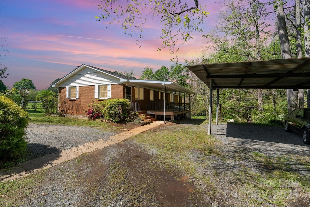 1331 Mccorkle Rd, Charlotte, NC 28214 - manufactured / mobile home featuring a carport, dirt driveway, brick siding, and covered porch