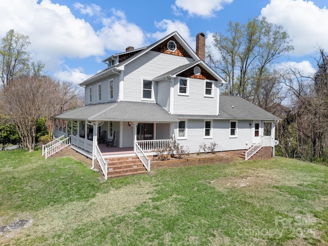 back of property with roof with shingles, a porch, a lawn, and a chimney
