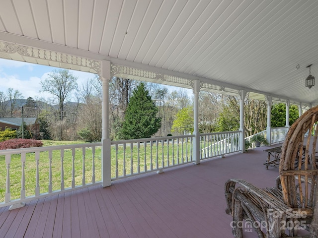 wooden terrace featuring a yard