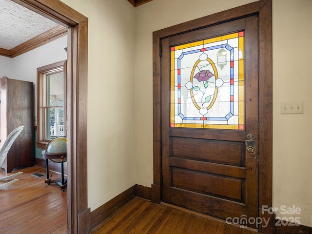 foyer entrance with baseboards, dark wood-style floors, visible vents, and crown molding