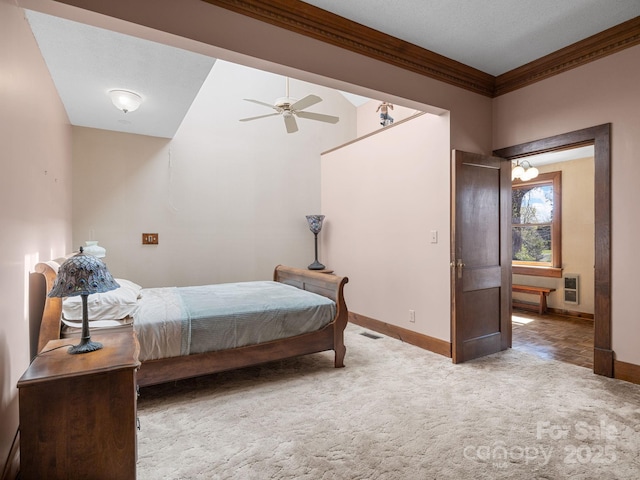 carpeted bedroom featuring visible vents, baseboards, crown molding, and ceiling fan