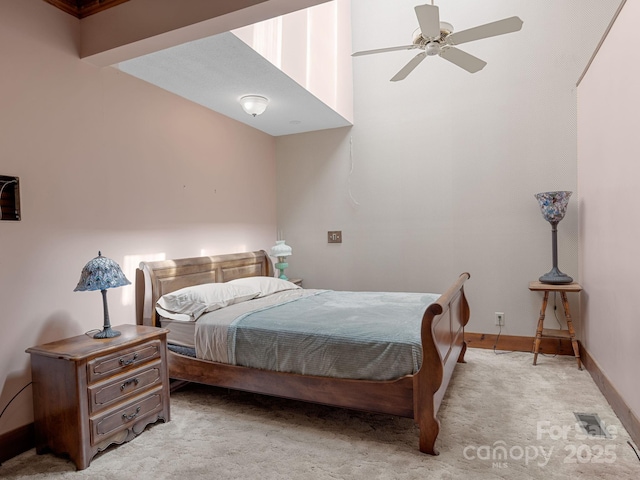 bedroom featuring visible vents, light colored carpet, baseboards, and a ceiling fan