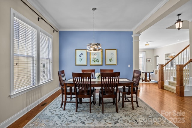 dining room with visible vents, ornamental molding, stairway, and wood finished floors