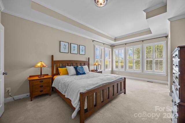carpeted bedroom with a tray ceiling, crown molding, and baseboards