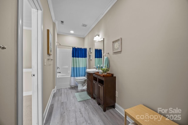 bathroom featuring vanity, ornamental molding, visible vents, wood finished floors, and shower / tub combo