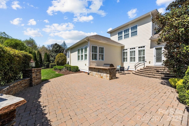 back of property featuring entry steps and a patio area