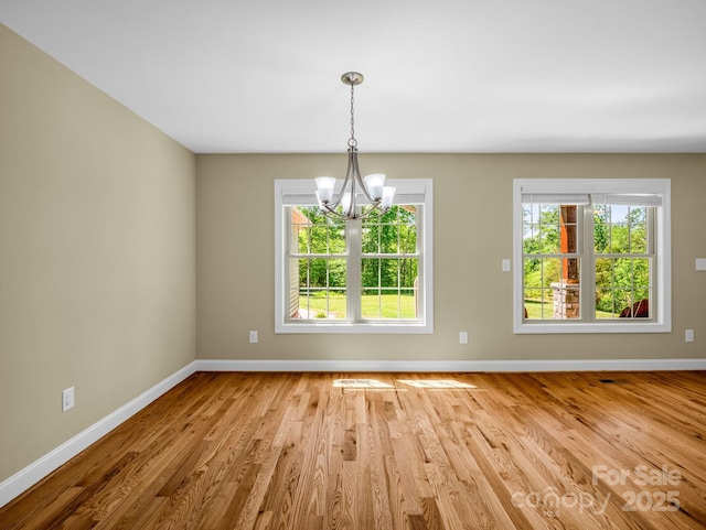 575 Hill Rd, Lincolnton, NC 28092 - unfurnished dining area featuring baseboards, a chandelier, a healthy amount of sunlight, and wood finished floors