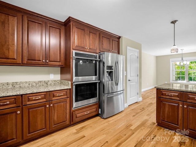 575 Hill Rd, Lincolnton, NC 28092 - kitchen featuring light stone countertops, baseboards, light wood finished floors, hanging light fixtures, and stainless steel appliances