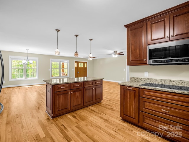 575 Hill Rd, Lincolnton, NC 28092 - kitchen featuring a kitchen island, black electric cooktop, stainless steel microwave, and light wood-style flooring