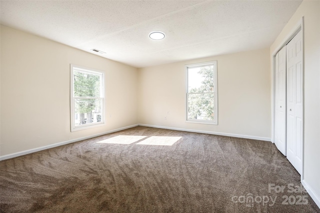 107 Maurice St, Monroe, NC 28112 - unfurnished bedroom featuring carpet flooring, visible vents, multiple windows, and a textured ceiling