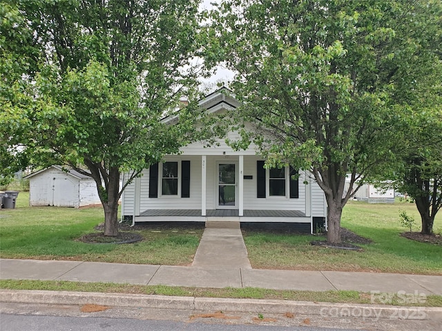 view of front of home with a porch, an outdoor structure, a shed, and a front lawn
