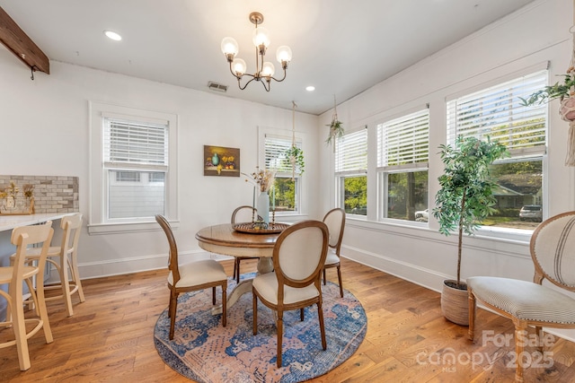 dining room featuring light wood-type flooring, visible vents, baseboards, and an inviting chandelier