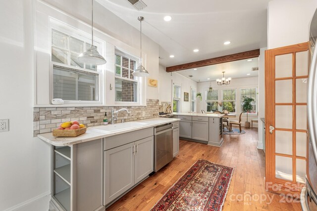 kitchen with stainless steel dishwasher, light wood-style flooring, tasteful backsplash, gray cabinets, and a sink